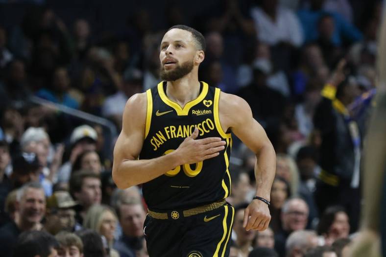 Mar 29, 2024; Charlotte, North Carolina, USA; Golden State Warriors guard Stephen Curry (30) pats his chest after making a three-point basket against the Charlotte Hornets during the first quarter at Spectrum Center. Mandatory Credit: Nell Redmond-USA TODAY Sports