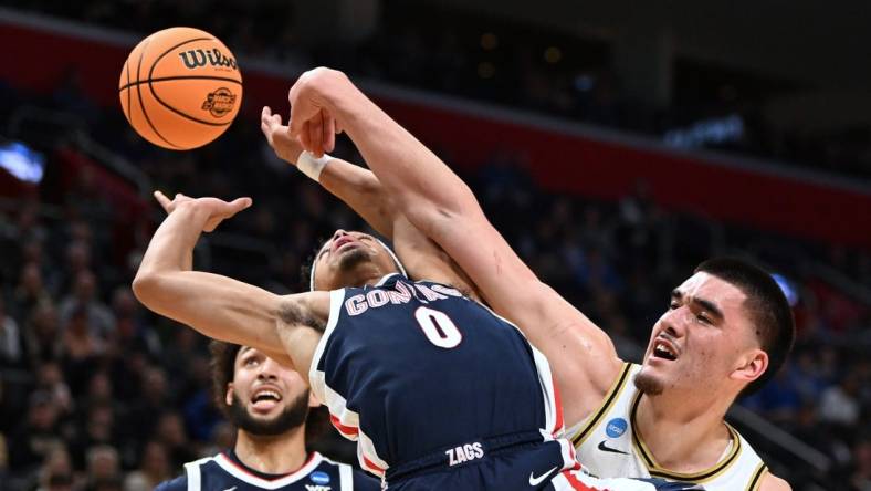 Mar 29, 2024; Detroit, MN, USA; Gonzaga Bulldogs guard Ryan Nembhard (0) battles Purdue Boilermakers center Zach Edey (15) for the ball in the first half during the NCAA Tournament Midwest Regional at Little Caesars Arena. Mandatory Credit: Lon Horwedel-USA TODAY Sports