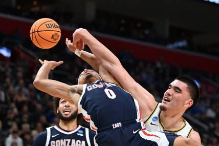 Mar 29, 2024; Detroit, MN, USA; Gonzaga Bulldogs guard Ryan Nembhard (0) battles Purdue Boilermakers center Zach Edey (15) for the ball in the first half during the NCAA Tournament Midwest Regional at Little Caesars Arena. Mandatory Credit: Lon Horwedel-USA TODAY Sports