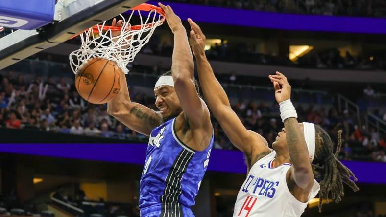 Mar 29, 2024; Orlando, Florida, USA; Orlando Magic center Wendell Carter Jr. (34) dunks in front of LA Clippers guard Terance Mann (14) during the second quarter at KIA Center. Mandatory Credit: Mike Watters-USA TODAY Sports