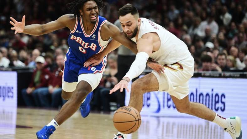 Mar 29, 2024; Cleveland, Ohio, USA; Philadelphia 76ers guard Tyrese Maxey (0) and Cleveland Cavaliers guard Max Strus (1) go for a loose ball during the first half at Rocket Mortgage FieldHouse. Mandatory Credit: Ken Blaze-USA TODAY Sports