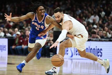 Mar 29, 2024; Cleveland, Ohio, USA; Philadelphia 76ers guard Tyrese Maxey (0) and Cleveland Cavaliers guard Max Strus (1) go for a loose ball during the first half at Rocket Mortgage FieldHouse. Mandatory Credit: Ken Blaze-USA TODAY Sports