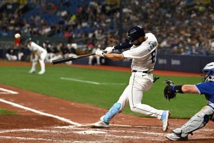 Mar 29, 2024; St. Petersburg, Florida, USA; Tampa Bay Rays second baseman Brandon Lowe (8) hits a grand slam in the third inning of the game against the Toronto Blue Jays  at Tropicana Field. Mandatory Credit: Jonathan Dyer-USA TODAY Sports
