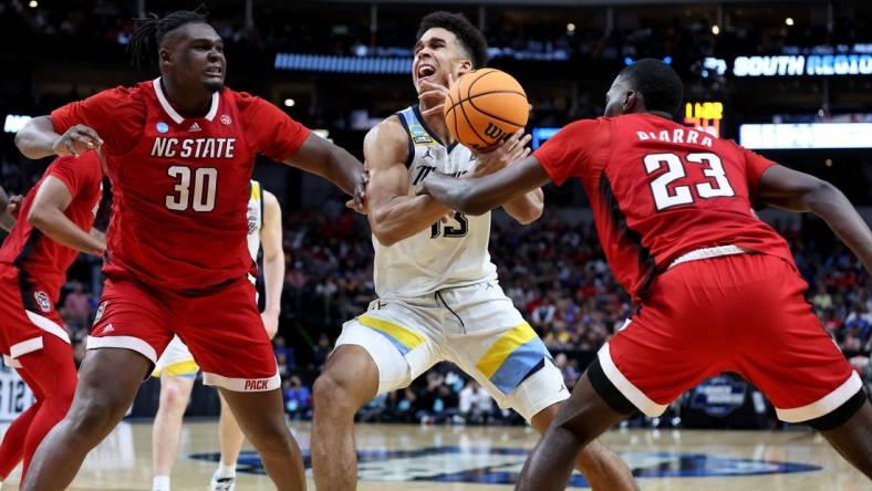 Mar 29, 2024; Dallas, TX, USA; North Carolina State Wolfpack forward Mohamed Diarra (23) knocks the ball away from Marquette Golden Eagles forward Oso Ighodaro (13) as North Carolina State Wolfpack forward DJ Burns Jr. (30) defends during the second half in the semifinals of the South Regional of the 2024 NCAA Tournament at American Airlines Center. Mandatory Credit: Tim Heitman-USA TODAY Sports