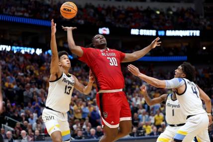 Mar 29, 2024; Dallas, TX, USA; North Carolina State Wolfpack forward DJ Burns Jr. (30) rebounds against Marquette Golden Eagles forward Oso Ighodaro (13),  guard Kam Jones (1) and guard Stevie Mitchell (4) during the second half in the semifinals of the South Regional of the 2024 NCAA Tournament at American Airlines Center. Mandatory Credit: Kevin Jairaj-USA TODAY Sports