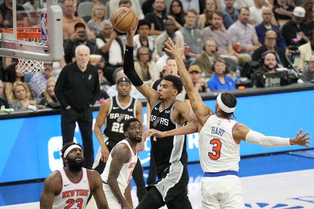 Mar 29, 2024; San Antonio, Texas, USA; San Antonio Spurs forward Victor Wembanyama (1) goes up to dunk over New York Knicks center Mitchell Robinson (23) and forward Josh Hart (3) during the first half at Frost Bank Center. Mandatory Credit: Scott Wachter-USA TODAY Sports