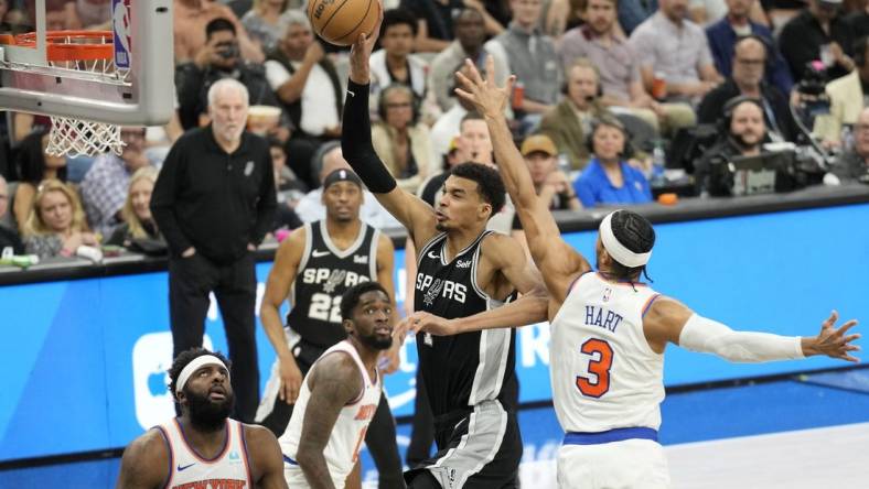 Mar 29, 2024; San Antonio, Texas, USA; San Antonio Spurs forward Victor Wembanyama (1) goes up to dunk over New York Knicks center Mitchell Robinson (23) and forward Josh Hart (3) during the first half at Frost Bank Center. Mandatory Credit: Scott Wachter-USA TODAY Sports