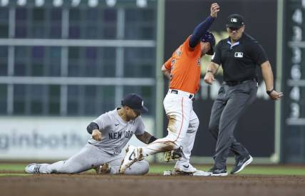Mar 29, 2024; Houston, Texas, USA; Houston Astros third baseman Alex Bregman (2) is safe at second base as New York Yankees second baseman Gleyber Torres (25) attempts to apply a tag during the third inning at Minute Maid Park. Mandatory Credit: Troy Taormina-USA TODAY Sports