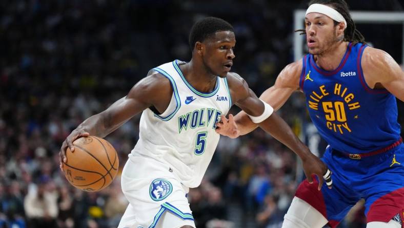 Mar 29, 2024; Denver, Colorado, USA; Minnesota Timberwolves guard Anthony Edwards (5) drives at Denver Nuggets forward Aaron Gordon (50) in the second quarter at Ball Arena. Mandatory Credit: Ron Chenoy-USA TODAY Sports