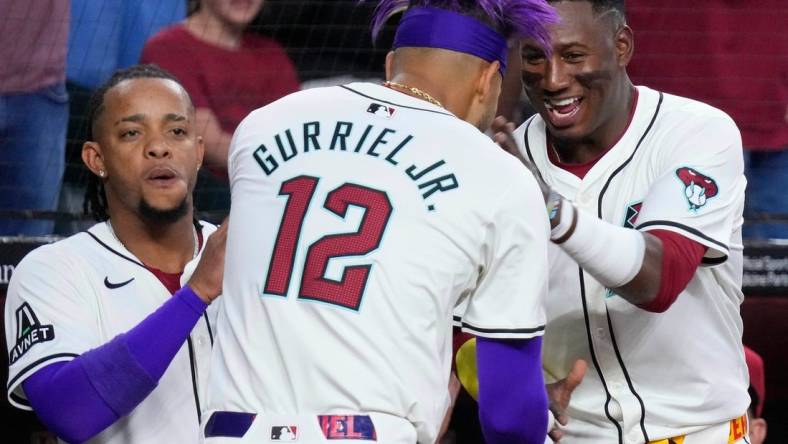 Diamondbacks Lourdes Gurriel Jr. (12) celebrates a home run against the Rockies with teammate Geraldo Perdomo (R) in the first inning during a game at Chase Field on March 29, 2024.