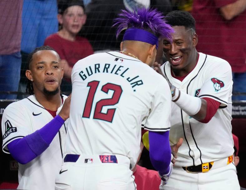 Diamondbacks Lourdes Gurriel Jr. (12) celebrates a home run against the Rockies with teammate Geraldo Perdomo (R) in the first inning during a game at Chase Field on March 29, 2024.