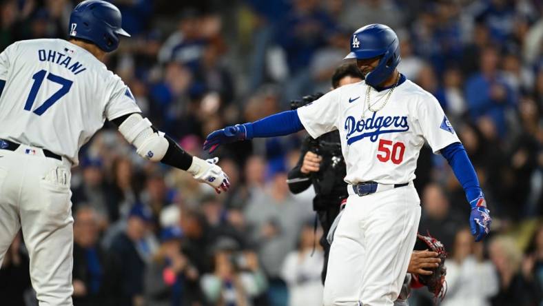 Mar 29, 2024; Los Angeles, California, USA; Los Angeles Dodgers second baseman Mookie Betts (50) hit fives designated hitter Shohei Ohtani (17)after hitting a home run against the St. Louis Cardinals during the first inning at Dodger Stadium. Mandatory Credit: Jonathan Hui-USA TODAY Sports