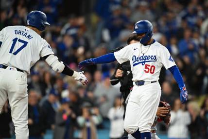Mar 29, 2024; Los Angeles, California, USA; Los Angeles Dodgers second baseman Mookie Betts (50) hit fives designated hitter Shohei Ohtani (17)after hitting a home run against the St. Louis Cardinals during the first inning at Dodger Stadium. Mandatory Credit: Jonathan Hui-USA TODAY Sports