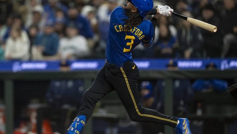 Mar 29, 2024; Seattle, Washington, USA; Seattle Mariners shortstop J.P. Crawford (3) hits a solo home run during the sixth inning against the Boston Red Sox at T-Mobile Park. Mandatory Credit: Stephen Brashear-USA TODAY Sports