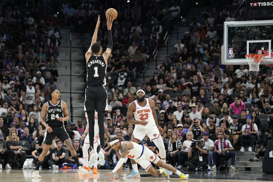 Mar 29, 2024; San Antonio, Texas, USA; San Antonio Spurs forward Victor Wembanyama (1) shoots a three pointer over New York Knicks guard Miles McBride (2) during overtime at Frost Bank Center. Mandatory Credit: Scott Wachter-USA TODAY Sports