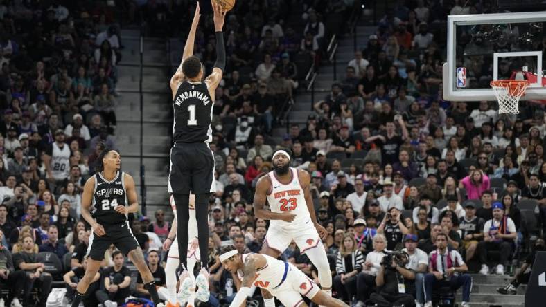 Mar 29, 2024; San Antonio, Texas, USA; San Antonio Spurs forward Victor Wembanyama (1) shoots a three pointer over New York Knicks guard Miles McBride (2) during overtime at Frost Bank Center. Mandatory Credit: Scott Wachter-USA TODAY Sports