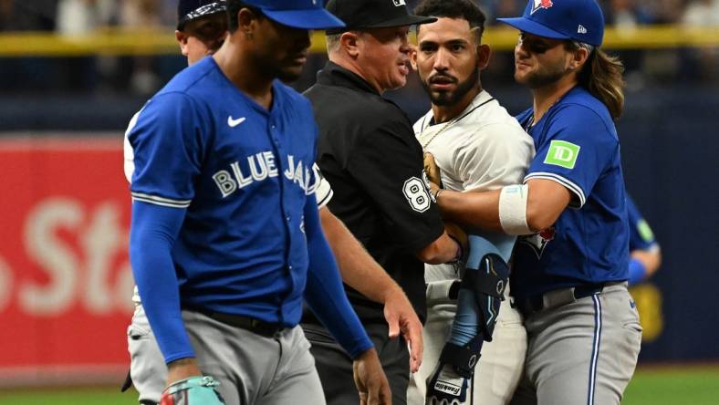 Mar 30, 2024; St. Petersburg, Florida, USA; Tampa Bay Rays shortstop Jose Caballero (7) stares at Toronto Blue Jays relief pitcher Genesis Cabrera (92) after they collide in the seventh inning of the game  at Tropicana Field. Mandatory Credit: Jonathan Dyer-USA TODAY Sports