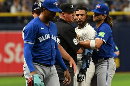 Mar 30, 2024; St. Petersburg, Florida, USA; Tampa Bay Rays shortstop Jose Caballero (7) stares at Toronto Blue Jays relief pitcher Genesis Cabrera (92) after they collide in the seventh inning of the game  at Tropicana Field. Mandatory Credit: Jonathan Dyer-USA TODAY Sports