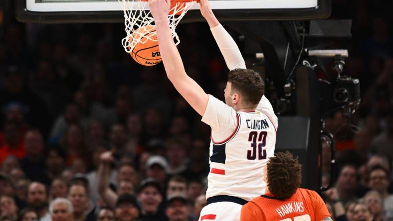 Mar 30, 2024; Boston, MA, USA; Connecticut Huskies center Donovan Clingan (32) dunks the ball against Illinois Fighting Illini forward Coleman Hawkins (33) in the finals of the East Regional of the 2024 NCAA Tournament at TD Garden. Mandatory Credit: Brian Fluharty-USA TODAY Sports