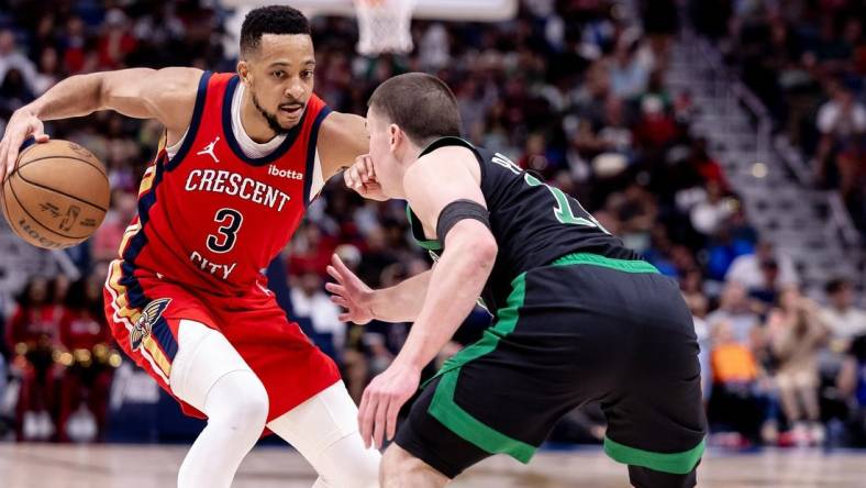 Mar 30, 2024; New Orleans, Louisiana, USA; New Orleans Pelicans guard CJ McCollum (3) dribbles against Boston Celtics guard Payton Pritchard (11) during the second half at Smoothie King Center. Mandatory Credit: Stephen Lew-USA TODAY Sports