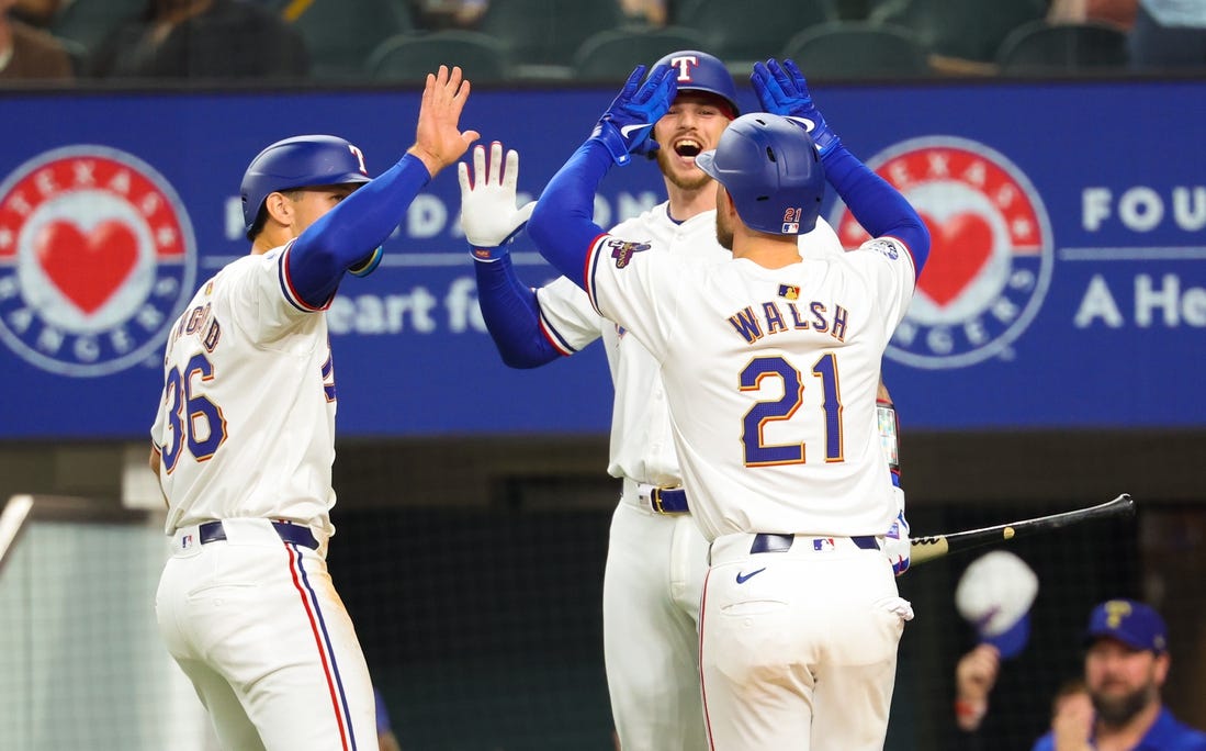 Mar 30, 2024; Arlington, Texas, USA;  Texas Rangers first baseman Jared Walsh (21) celebrates with Texas Rangers designated hitter Wyatt Langford (36) and Texas Rangers catcher Jonah Heim (28) after hitting a two-run home run during the second inning against the Chicago Cubs at Globe Life Field. Mandatory Credit: Kevin Jairaj-USA TODAY Sports