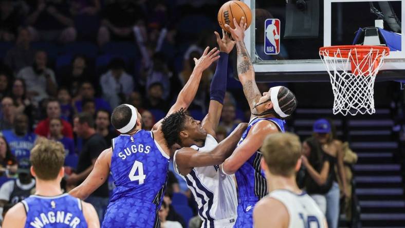 Mar 30, 2024; Orlando, Florida, USA; Orlando Magic forward Paolo Banchero (5) and guard Jalen Suggs (4) block a shot attempt by Memphis Grizzlies forward GG Jackson (45) during the first quarter at KIA Center. Mandatory Credit: Mike Watters-USA TODAY Sports