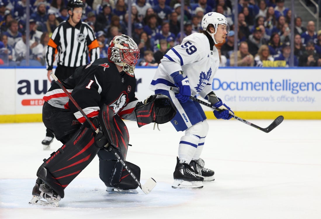 Mar 30, 2024; Buffalo, New York, USA;  Buffalo Sabres goaltender Ukko-Pekka Luukkonen (1) and Toronto Maple Leafs left wing Tyler Bertuzzi (59) look for the puck during the first period at KeyBank Center. Mandatory Credit: Timothy T. Ludwig-USA TODAY Sports