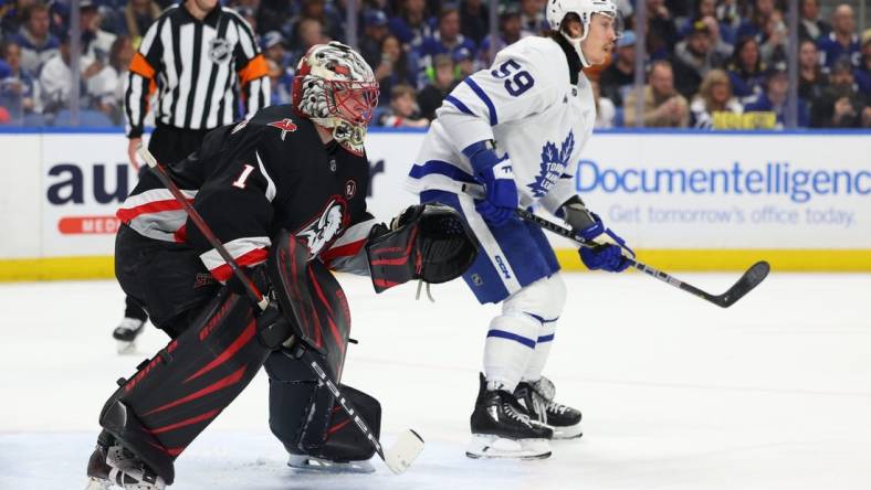 Mar 30, 2024; Buffalo, New York, USA;  Buffalo Sabres goaltender Ukko-Pekka Luukkonen (1) and Toronto Maple Leafs left wing Tyler Bertuzzi (59) look for the puck during the first period at KeyBank Center. Mandatory Credit: Timothy T. Ludwig-USA TODAY Sports