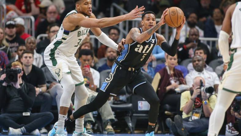 Mar 30, 2024; Atlanta, Georgia, USA; Milwaukee Bucks forward Giannis Antetokounmpo (34) defends Atlanta Hawks guard Dejounte Murray (5) in the first quarter at State Farm Arena. Mandatory Credit: Brett Davis-USA TODAY Sports