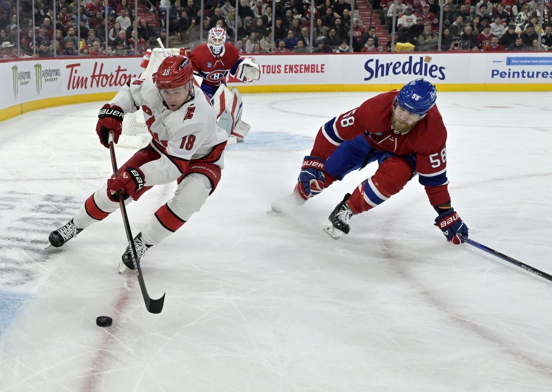 Mar 30, 2024; Montreal, Quebec, CAN; Carolina Hurricanes forward Jack Drury (18) plays the puck and Montreal Canadiens defenseman David Savard (58) defends during the first period at the Bell Centre. Mandatory Credit: Eric Bolte-USA TODAY Sports