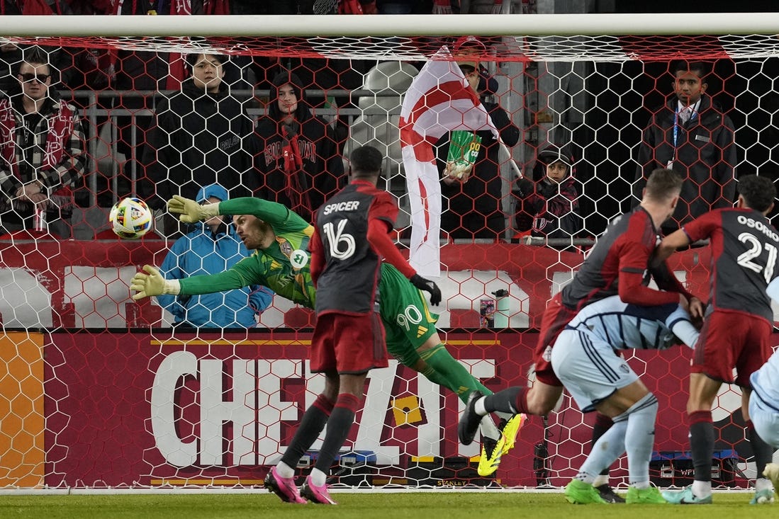 Mar 30, 2024; Toronto, Ontario, USA; Toronto FC goalkeeper Luka Gavran (90) dives to make a stop against Sporting Kansas City during the first half at BMO Field. Mandatory Credit: Nick Turchiaro-USA TODAY Sports