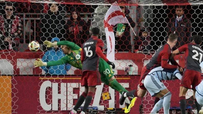 Mar 30, 2024; Toronto, Ontario, USA; Toronto FC goalkeeper Luka Gavran (90) dives to make a stop against Sporting Kansas City during the first half at BMO Field. Mandatory Credit: Nick Turchiaro-USA TODAY Sports