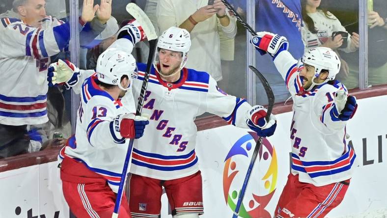 Mar 30, 2024; Tempe, Arizona, USA; New York Rangers defenseman Zac Jones (6) celebrates with left wing Alexis Lafreniere (13) and center Vincent Trocheck (16) after scoring a goal in the third period against the Arizona Coyotes at Mullett Arena. Mandatory Credit: Matt Kartozian-USA TODAY Sports