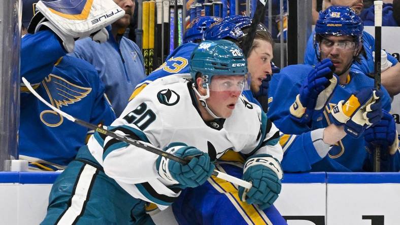 Mar 30, 2024; St. Louis, Missouri, USA;  San Jose Sharks left wing Fabian Zetterlund (20) checks St. Louis Blues left wing Jake Neighbours (63) during the first period at Enterprise Center. Mandatory Credit: Jeff Curry-USA TODAY Sports