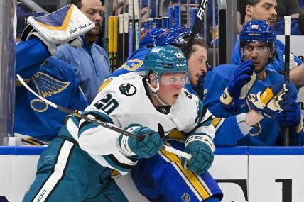 Mar 30, 2024; St. Louis, Missouri, USA;  San Jose Sharks left wing Fabian Zetterlund (20) checks St. Louis Blues left wing Jake Neighbours (63) during the first period at Enterprise Center. Mandatory Credit: Jeff Curry-USA TODAY Sports