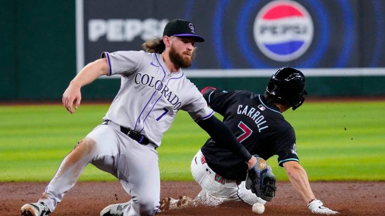 Rockies Brendan Rodgers (7) drops the ball before applying a late tag to Diamondbacks Corbin Carroll (7) as he slides safely into second for a steal during a game at Chase Field.