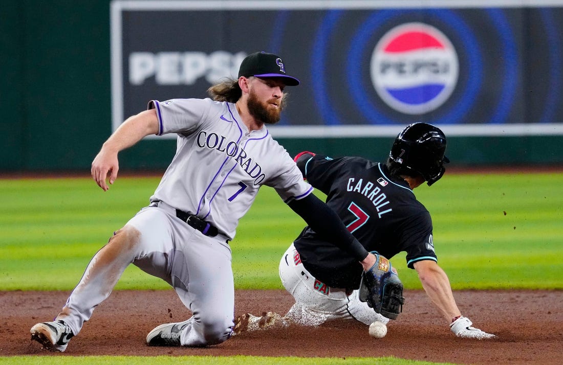 Rockies Brendan Rodgers (7) drops the ball before applying a late tag to Diamondbacks Corbin Carroll (7) as he slides safely into second for a steal during a game at Chase Field.