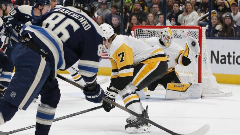 Mar 30, 2024; Columbus, Ohio, USA; Pittsburgh Penguins goalie Alex Nedeljkovic (39) makes a glove save on the shot attempt of Columbus Blue Jackets right wing Kirill Marchenko (86) during the first period at Nationwide Arena. Mandatory Credit: Russell LaBounty-USA TODAY Sports