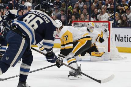 Mar 30, 2024; Columbus, Ohio, USA; Pittsburgh Penguins goalie Alex Nedeljkovic (39) makes a glove save on the shot attempt of Columbus Blue Jackets right wing Kirill Marchenko (86) during the first period at Nationwide Arena. Mandatory Credit: Russell LaBounty-USA TODAY Sports