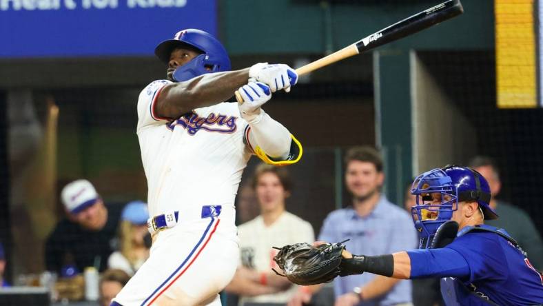 Mar 30, 2024; Arlington, Texas, USA;  Texas Rangers right fielder Adolis Garcia (53) hits a sacrifice fly rbi during the eighth inning against the Chicago Cubs at Globe Life Field. Mandatory Credit: Kevin Jairaj-USA TODAY Sports