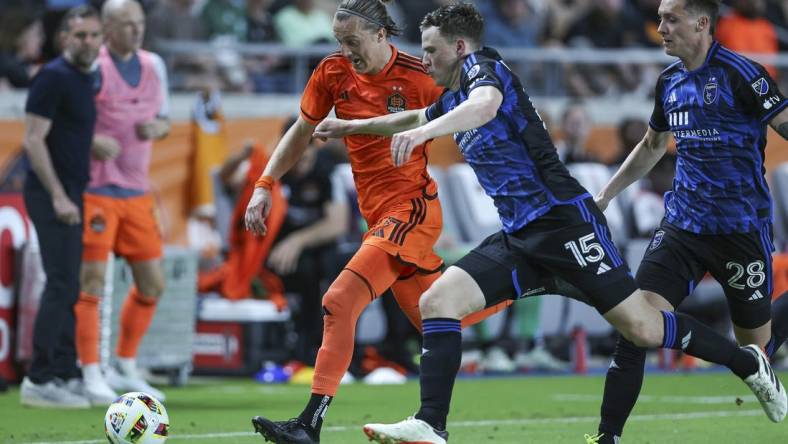 Mar 30, 2024; Houston, Texas, USA; Houston Dynamo FC midfielder Griffin Dorsey (25) attempts to advance the ball as San Jose Earthquakes defender Tanner Beason (15) defends during the second half at Shell Energy Stadium. Mandatory Credit: Troy Taormina-USA TODAY Sports