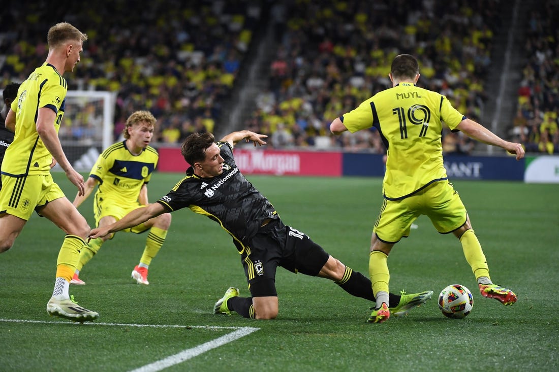 Mar 30, 2024; Nashville, Tennessee, USA; Columbus Crew defender Malte Amundsen (18) kick the ball away from Nashville SC midfielder Alex Muyl (19) in the second half at Geodis Park. Mandatory Credit: Christopher Hanewinckel-USA TODAY Sports