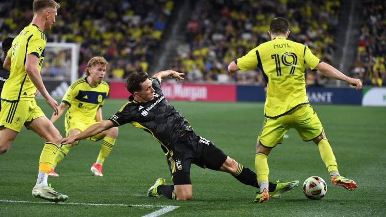 Mar 30, 2024; Nashville, Tennessee, USA; Columbus Crew defender Malte Amundsen (18) kick the ball away from Nashville SC midfielder Alex Muyl (19) in the second half at Geodis Park. Mandatory Credit: Christopher Hanewinckel-USA TODAY Sports