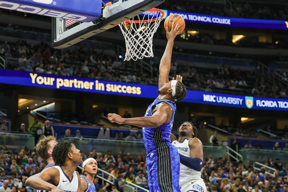 Mar 30, 2024; Orlando, Florida, USA; Orlando Magic center Wendell Carter Jr. (34) blocks a shot attempt by Memphis Grizzlies forward Jaren Jackson Jr. (13) during the second half at KIA Center. Mandatory Credit: Mike Watters-USA TODAY Sports