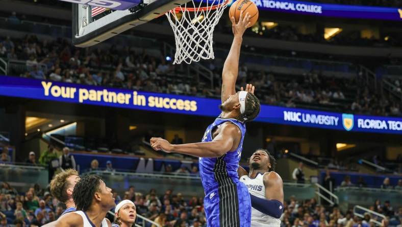 Mar 30, 2024; Orlando, Florida, USA; Orlando Magic center Wendell Carter Jr. (34) blocks a shot attempt by Memphis Grizzlies forward Jaren Jackson Jr. (13) during the second half at KIA Center. Mandatory Credit: Mike Watters-USA TODAY Sports