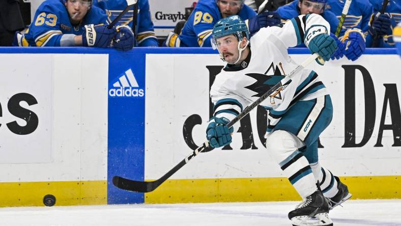 Mar 30, 2024; St. Louis, Missouri, USA;  San Jose Sharks defenseman Kyle Burroughs (4) shoots against the St. Louis Blues during the third period at Enterprise Center. Mandatory Credit: Jeff Curry-USA TODAY Sports