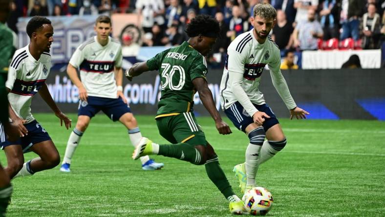 Mar 30, 2024; Vancouver, British Columbia, CAN; Portland Timbers forward Santiago Moreno (30) shoots as Vancouver Whitecaps FC defender Tristan Blackmon (6) defends during the first half at BC Place. Mandatory Credit: Simon Fearn-USA TODAY Sports