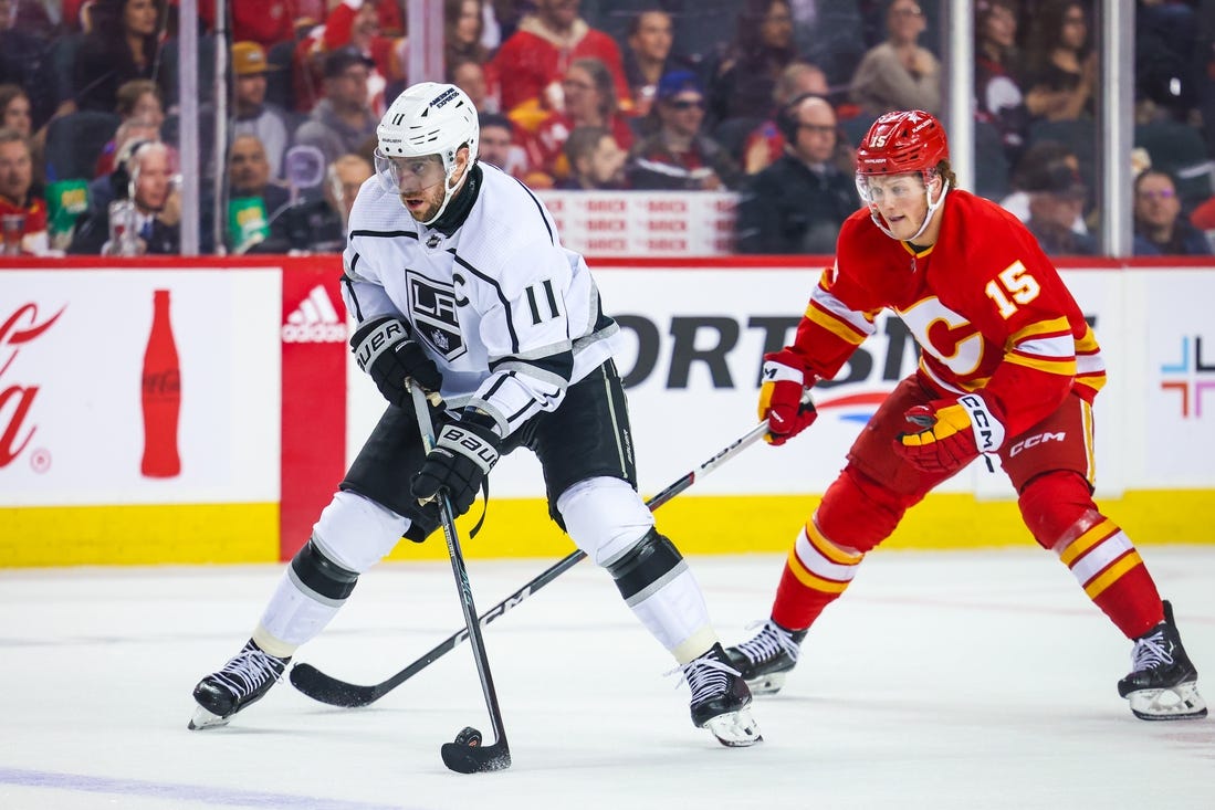 Mar 30, 2024; Calgary, Alberta, CAN; Los Angeles Kings center Anze Kopitar (11) controls the puck against the Calgary Flames during the third period at Scotiabank Saddledome. Mandatory Credit: Sergei Belski-USA TODAY Sports