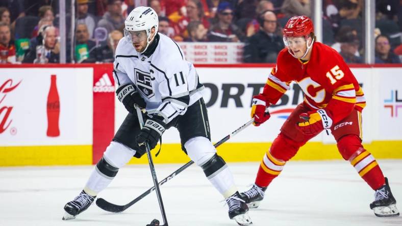 Mar 30, 2024; Calgary, Alberta, CAN; Los Angeles Kings center Anze Kopitar (11) controls the puck against the Calgary Flames during the third period at Scotiabank Saddledome. Mandatory Credit: Sergei Belski-USA TODAY Sports