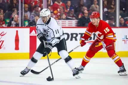 Mar 30, 2024; Calgary, Alberta, CAN; Los Angeles Kings center Anze Kopitar (11) controls the puck against the Calgary Flames during the third period at Scotiabank Saddledome. Mandatory Credit: Sergei Belski-USA TODAY Sports
